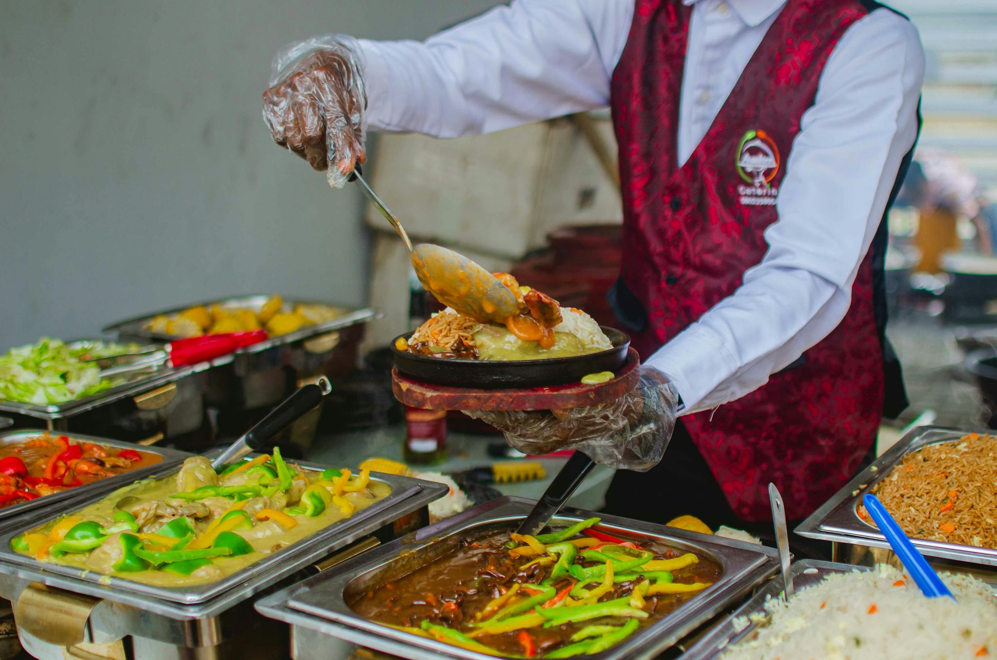 A chef expertly serves a variety of colorful dishes at a buffet, highlighting culinary expertise.