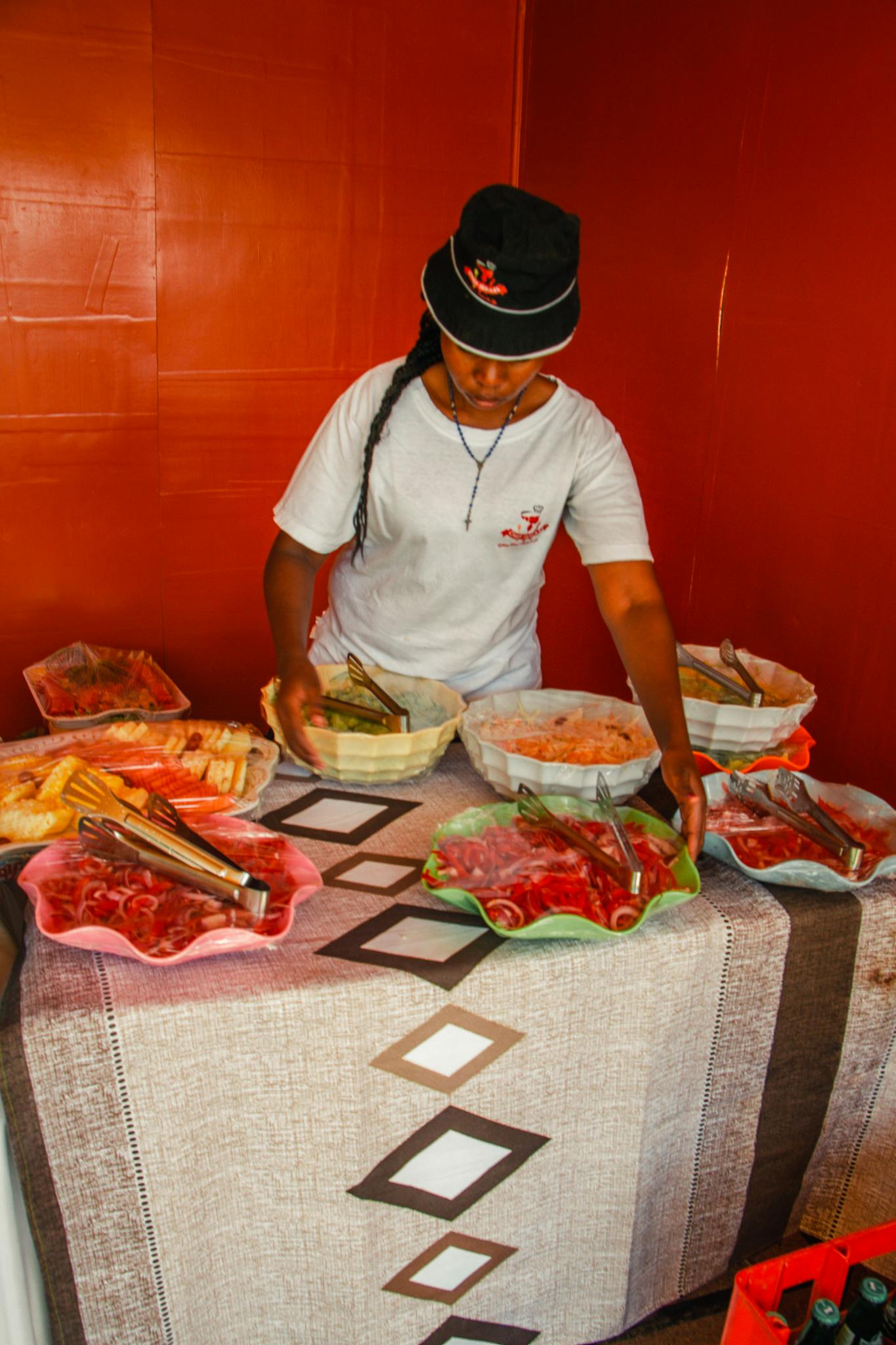 African American woman preparing buffet table at Nairobi event.
